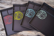 Load image into Gallery viewer, Four Brian Brown EDC Tear Down Trays displayed side by side, showing all available logo color options in the 3D printed knife maintenance workspace design