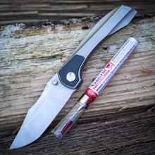 Load image into Gallery viewer, Brian Brown Raptor folding knife and a tube of Nano-Oil on a wooden surface